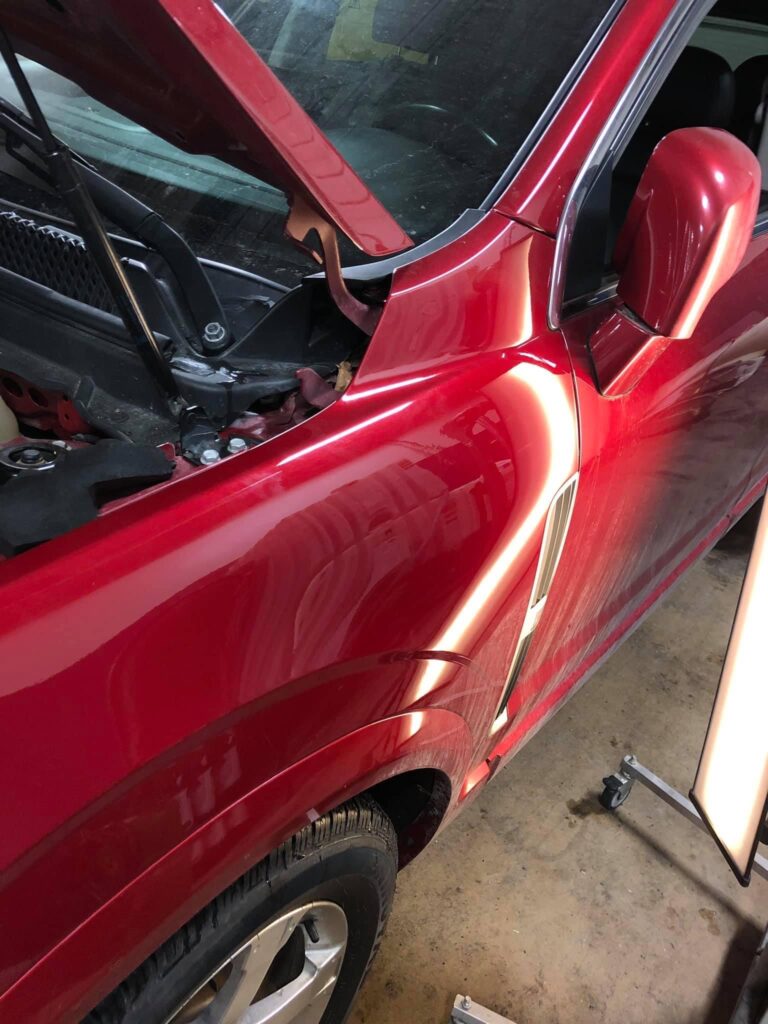 After picture of paintless dent repair on a red vehicle